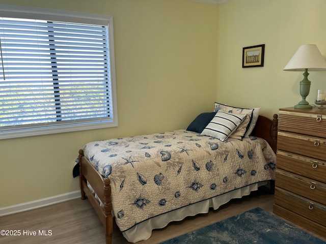 bedroom featuring baseboards and wood finished floors