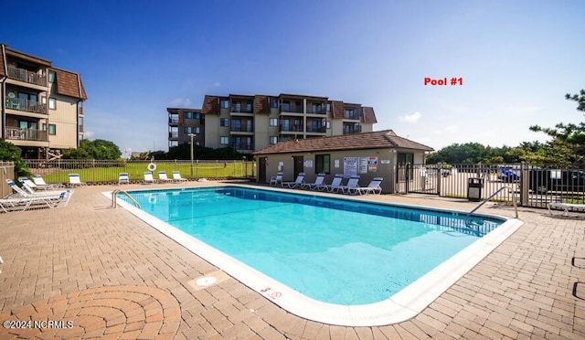 pool with a patio area and fence