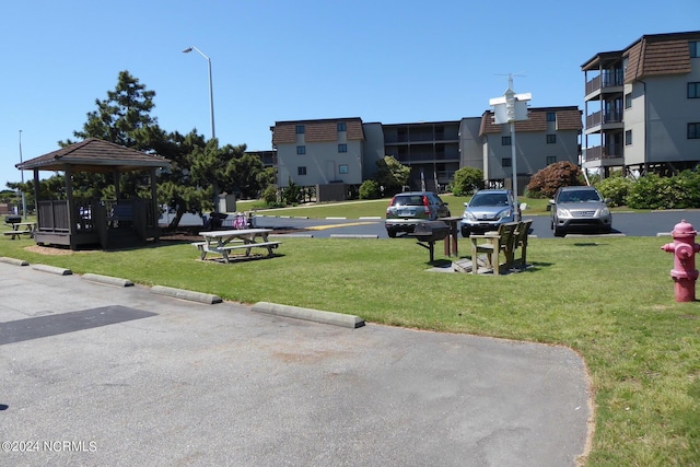 view of home's community with uncovered parking, a lawn, and a gazebo