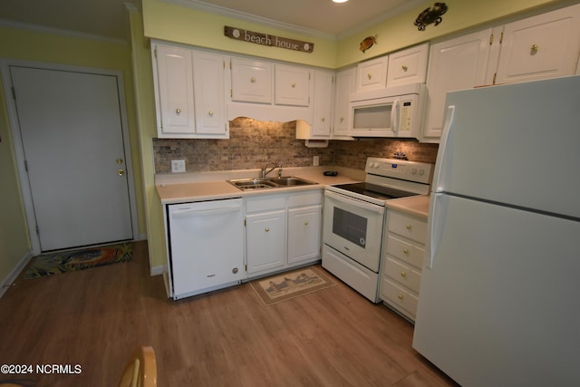 kitchen featuring white appliances, a sink, white cabinetry, and crown molding