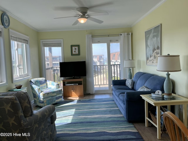 living area with ornamental molding, wood finished floors, and a ceiling fan