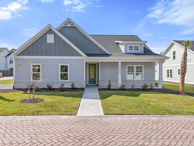 view of front of property featuring covered porch and a front yard