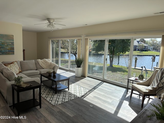 living room with a water view, ceiling fan, and hardwood / wood-style flooring