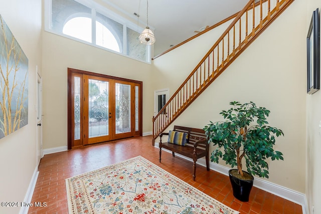 foyer featuring french doors and a towering ceiling