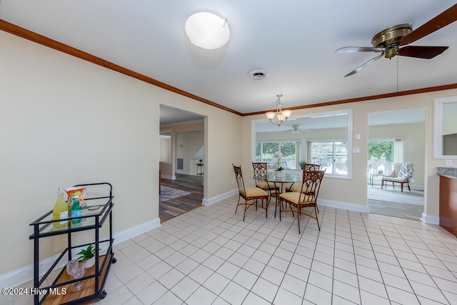 tiled dining room with ceiling fan with notable chandelier and ornamental molding