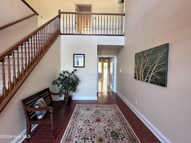 foyer entrance featuring a high ceiling and dark hardwood / wood-style flooring