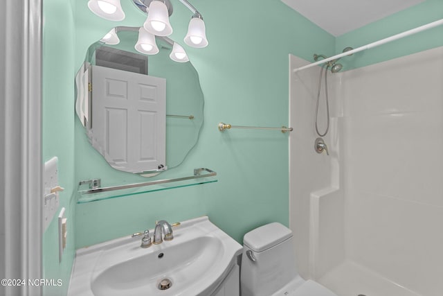 bathroom featuring walk in shower, vanity, and toilet