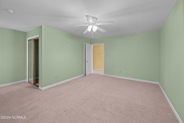 unfurnished bedroom with light carpet, ceiling fan, and a closet