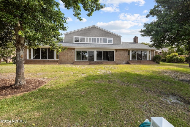 rear view of house featuring a yard