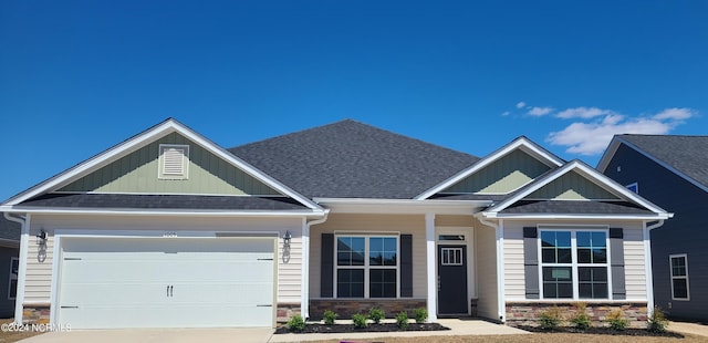 craftsman house featuring an attached garage, a shingled roof, stone siding, driveway, and board and batten siding