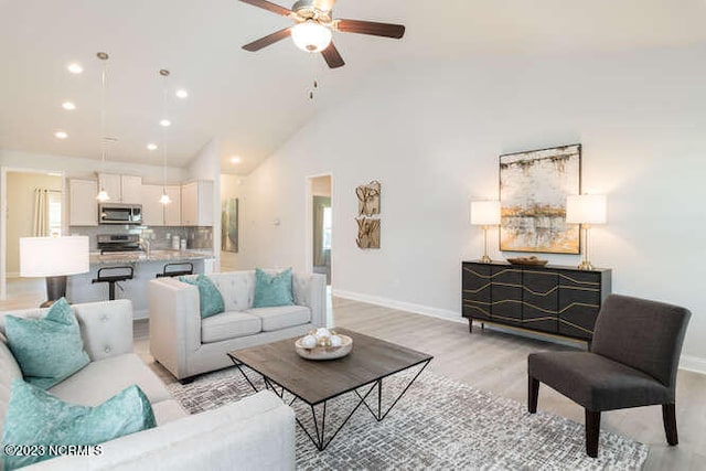 living room featuring high vaulted ceiling, ceiling fan, and light hardwood / wood-style floors