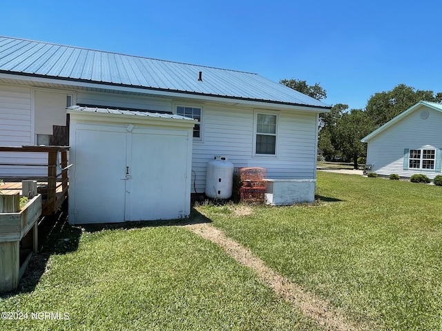 rear view of house with metal roof and a yard