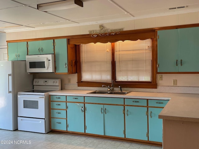 kitchen with white appliances, light countertops, a sink, and light floors