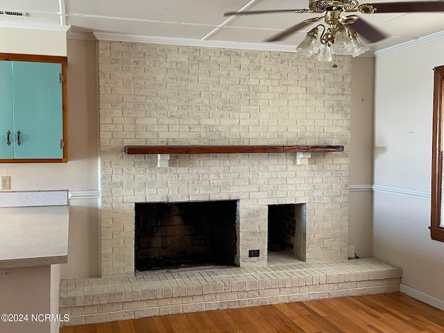 room details with ornamental molding, a brick fireplace, visible vents, and wood finished floors