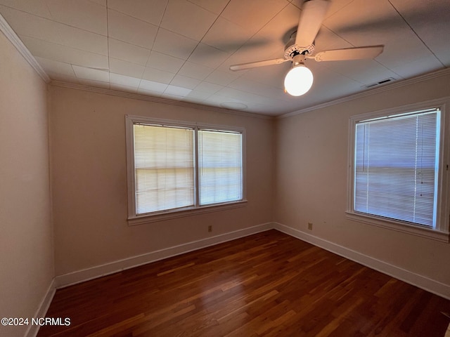 unfurnished room with wood finished floors, a ceiling fan, visible vents, baseboards, and ornamental molding