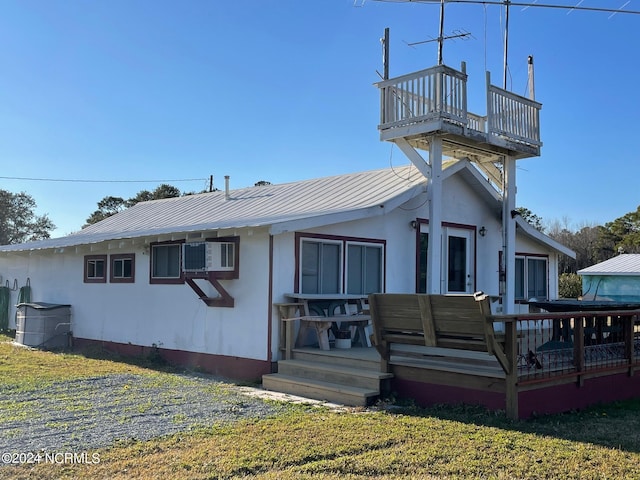 view of front of house featuring metal roof, a balcony, and a wall mounted AC