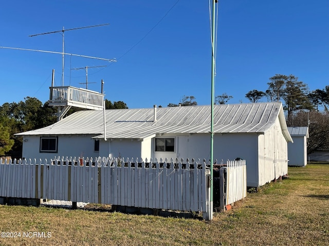 exterior space with metal roof, a yard, and fence