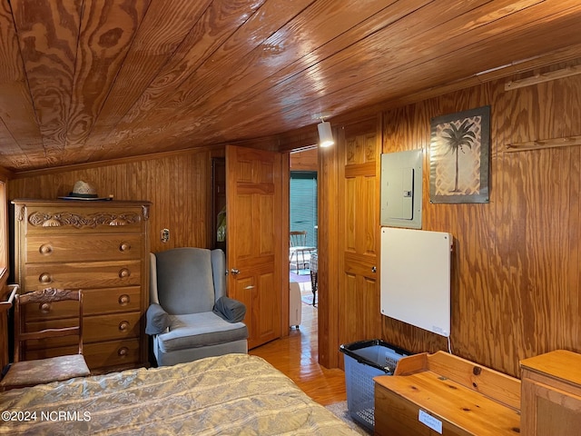 bedroom with wood walls, wood ceiling, electric panel, and light wood-style flooring