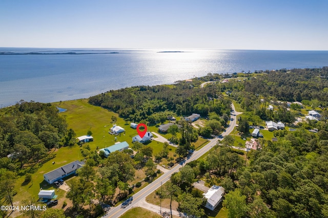 birds eye view of property featuring a forest view and a water view