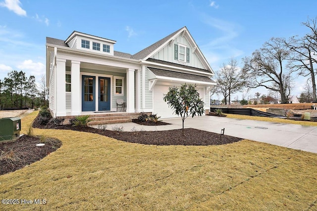 craftsman-style home featuring a garage, a front lawn, and covered porch