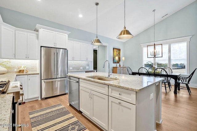 kitchen with white cabinetry, sink, decorative light fixtures, and appliances with stainless steel finishes