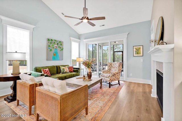 living room featuring high vaulted ceiling, ceiling fan, and light wood-type flooring