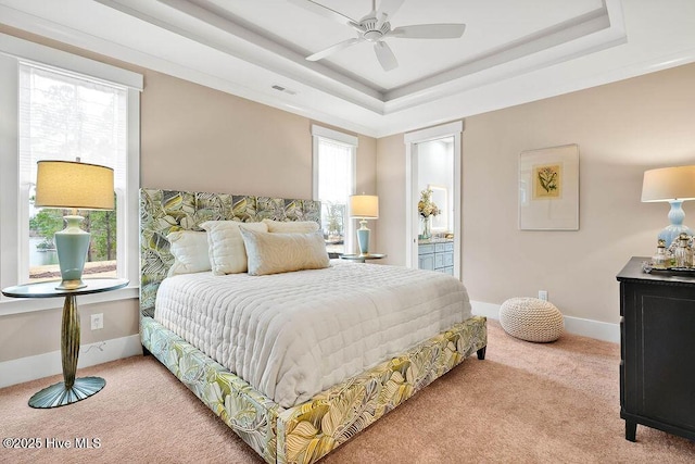 carpeted bedroom with ceiling fan and a tray ceiling