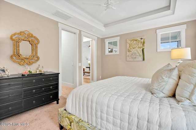 bedroom featuring a raised ceiling, crown molding, light colored carpet, and ceiling fan