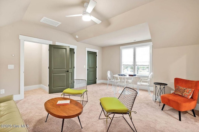 living area with vaulted ceiling, light colored carpet, and ceiling fan