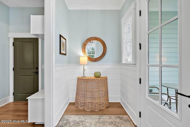 foyer entrance with ornamental molding and light hardwood / wood-style floors