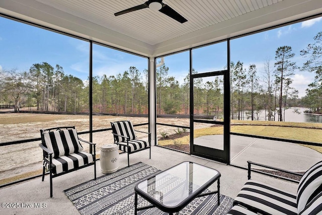 sunroom featuring a water view, a wealth of natural light, and ceiling fan