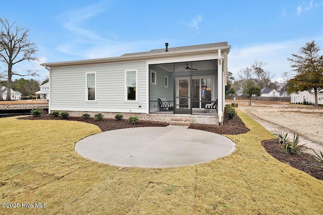 back of property with a sunroom, ceiling fan, and a lawn