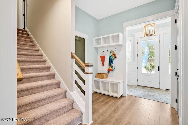 mudroom with an inviting chandelier and light wood-type flooring