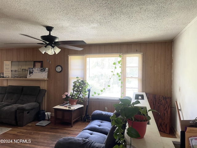 living room featuring a healthy amount of sunlight, a textured ceiling, and wooden walls