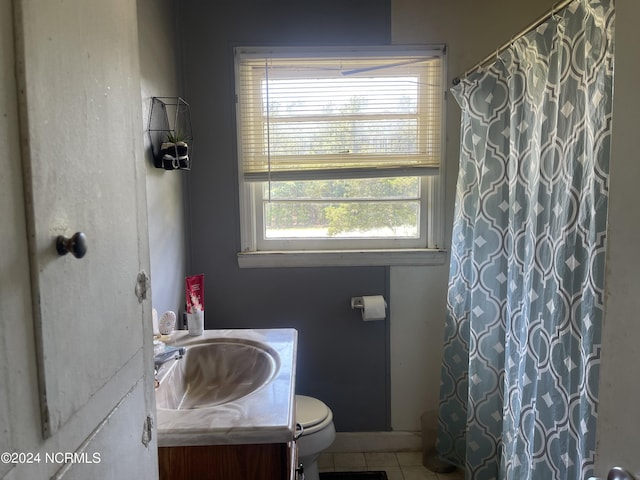 bathroom with vanity, tile patterned floors, toilet, and a healthy amount of sunlight