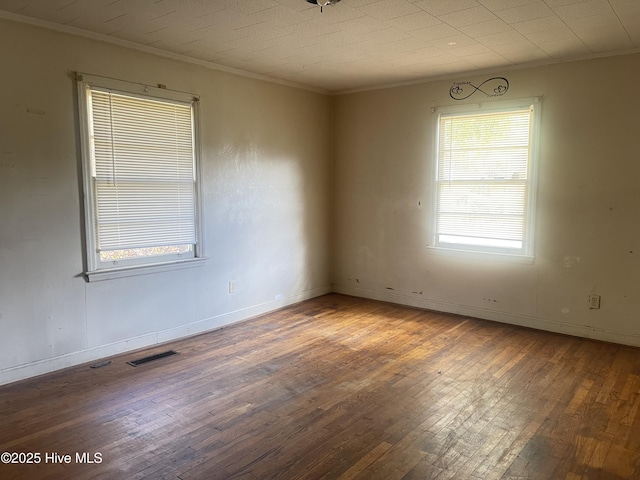 spare room featuring crown molding and dark hardwood / wood-style floors