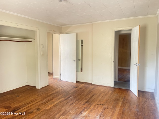 unfurnished bedroom featuring crown molding and dark hardwood / wood-style flooring