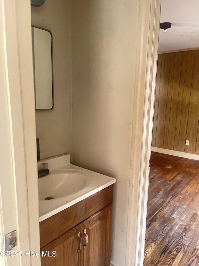 bathroom with vanity, wood-type flooring, and wood walls