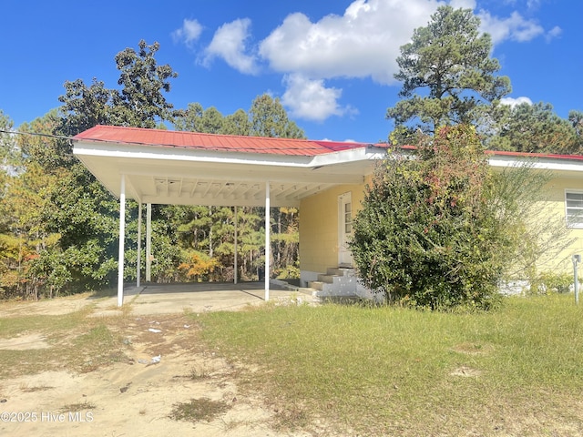 exterior space featuring a carport and a lawn