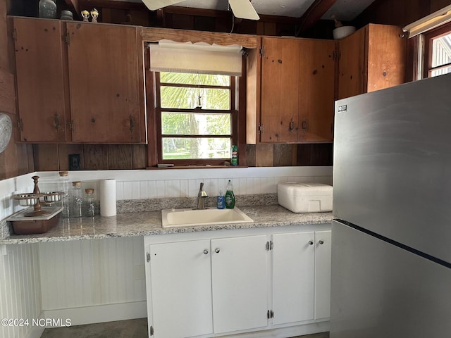 kitchen featuring a healthy amount of sunlight, stainless steel refrigerator, sink, and ceiling fan