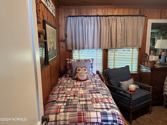 carpeted bedroom featuring wooden walls