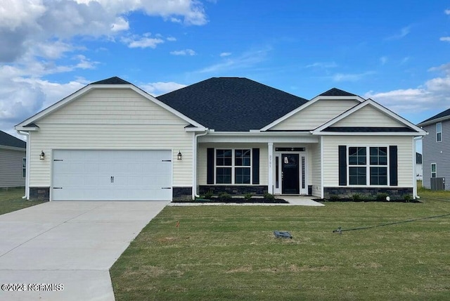 view of front of property with a shingled roof, a front lawn, concrete driveway, stone siding, and an attached garage