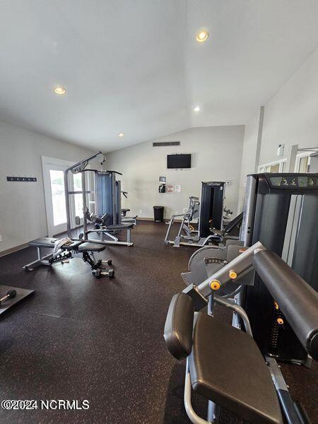 exercise room with recessed lighting, baseboards, and vaulted ceiling