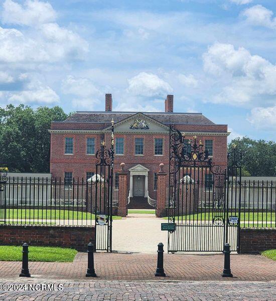 view of front of home with a fenced front yard, brick siding, and a gate