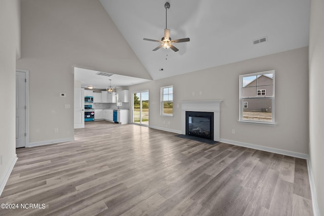 200 Slater Way, Jacksonville, NC 28540 - unfurnished living room featuring high vaulted ceiling, a glass covered fireplace, a ceiling fan, light wood-type flooring, and baseboards