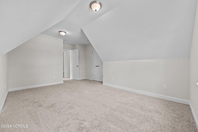 additional living space with light carpet and lofted ceiling