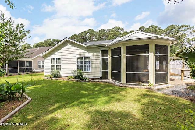 rear view of property with a sunroom, a yard, and fence