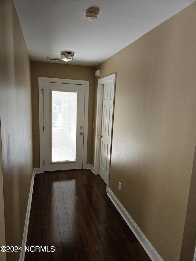 doorway to outside featuring dark wood finished floors and baseboards