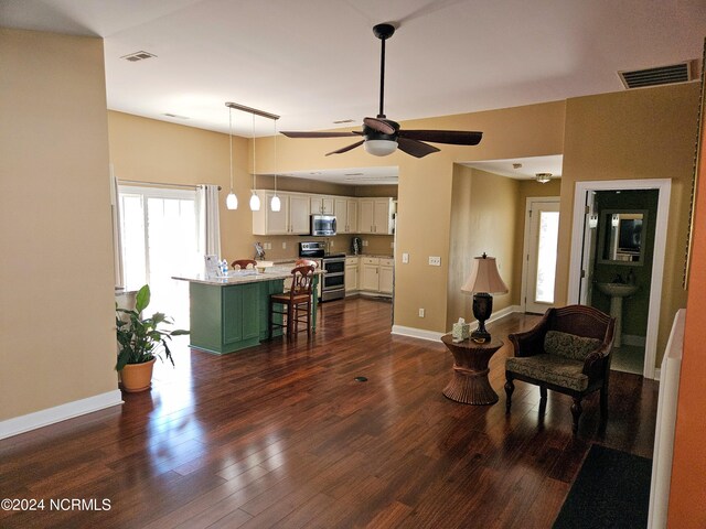 living area with baseboards, visible vents, and dark wood-style flooring