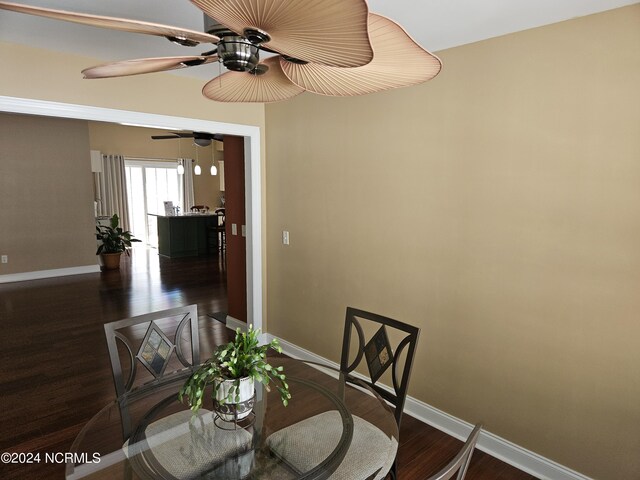 dining area featuring wood finished floors, a ceiling fan, and baseboards